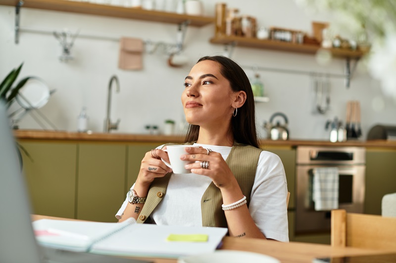 Vrouw met kop koffie aan tafel